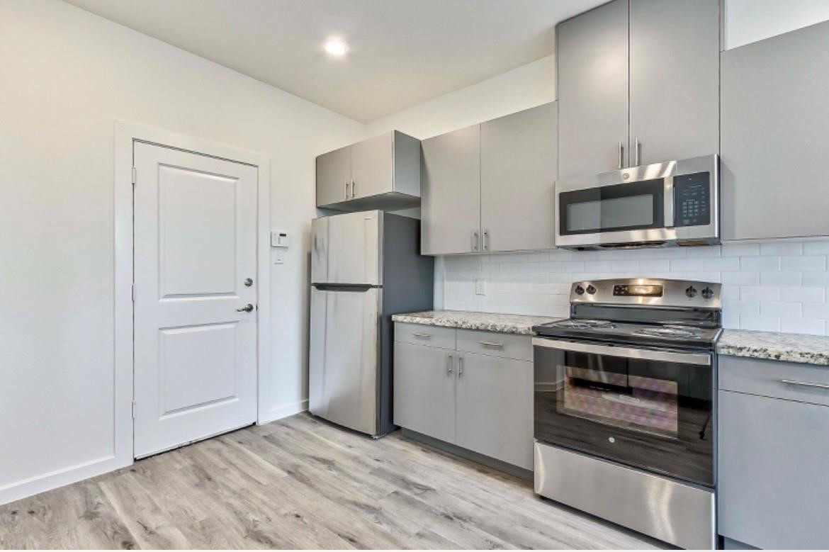 4810 Centipede Road, Unit B Houston, TX 77048 - Photo 6 of 19 a kitchen with a stove and a microwave