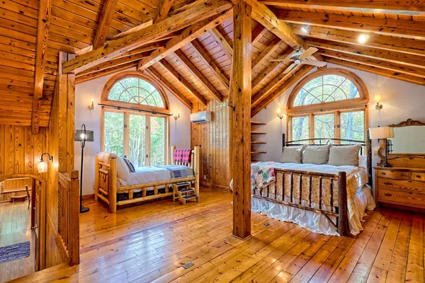 a view of a porch with wooden floor and roof with a garden view
