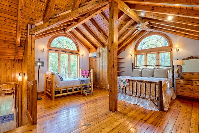 a view of a porch with wooden floor and roof with a garden view