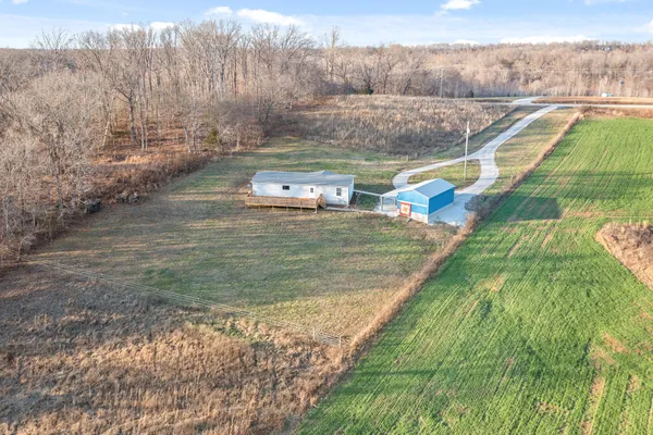 a view of a lake with a yard and large trees
