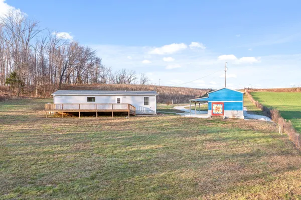 a house view with a big yard plants and large trees