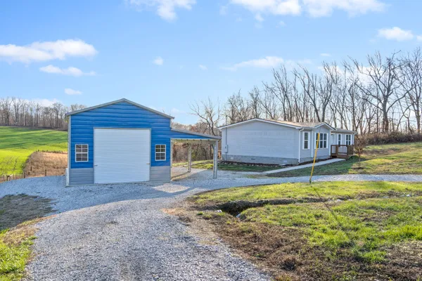 a backyard of a house with barbeque oven a table and chairs