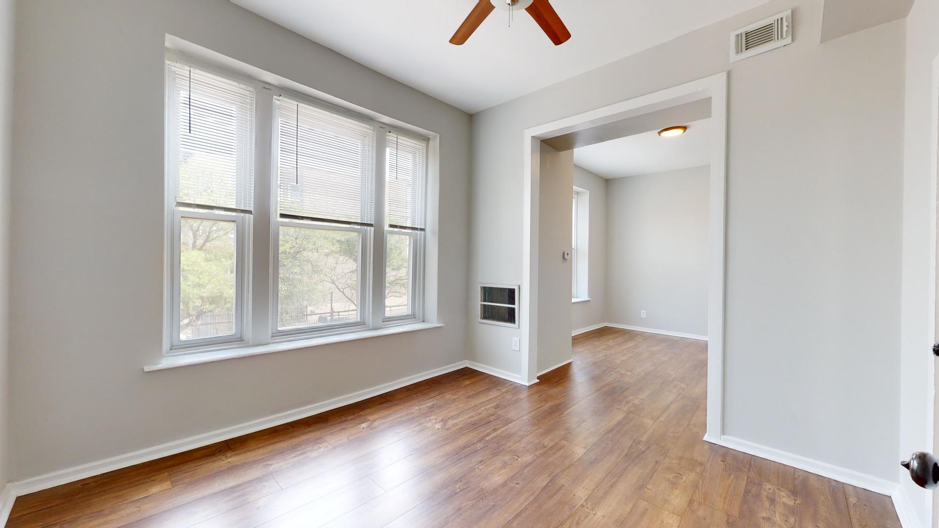 2700 West Cermak Road, Unit 2R Chicago, IL 60608 - Photo 2 of 15 an empty room with wooden floor and windows