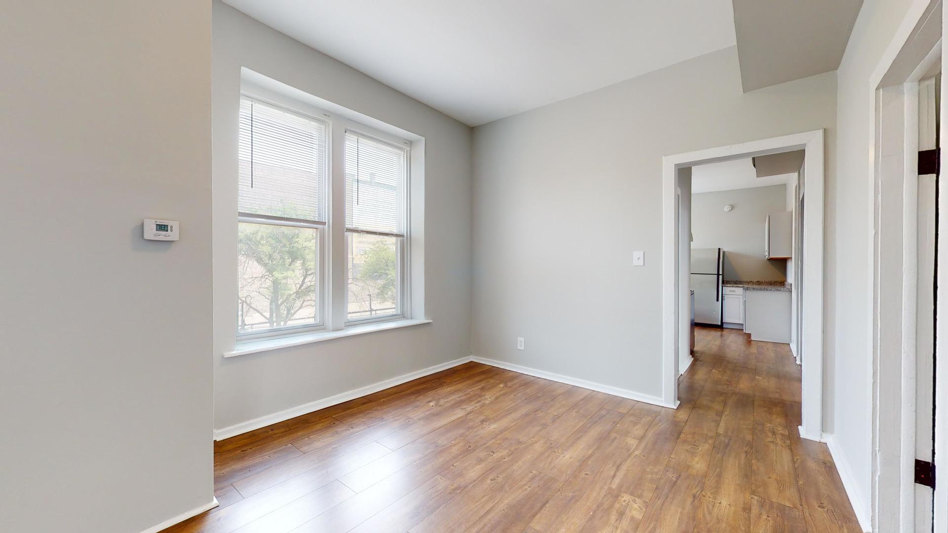 2700 West Cermak Road, Unit 2R Chicago, IL 60608 - Photo 4 of 15 an empty room with wooden floor and a window