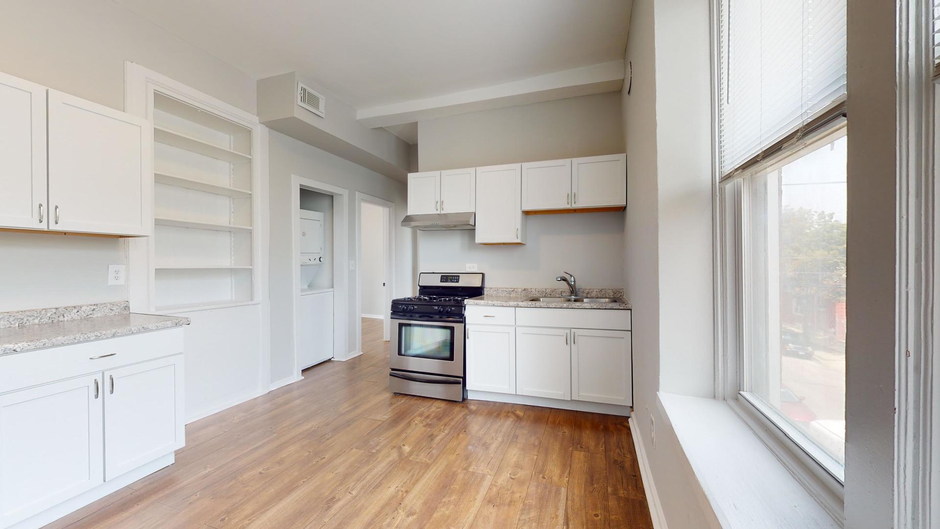 2700 West Cermak Road, Unit 2R Chicago, IL 60608 - Photo 6 of 15 a kitchen with a sink cabinets stainless steel appliances and a window