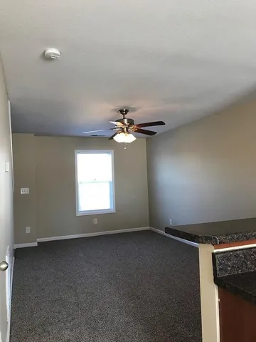 en empty room with windows and fan