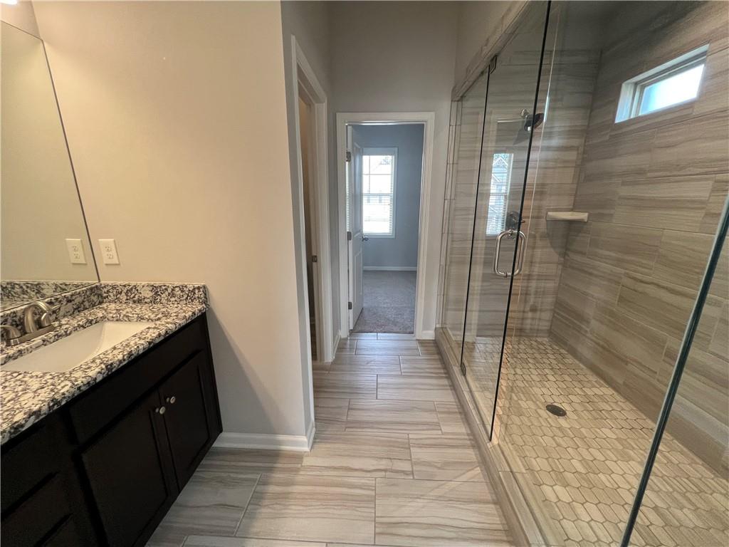 3434 IVY FARM Path Buford, GA 30519 - Photo 25 of 37 a bathroom with a granite countertop sink and shower