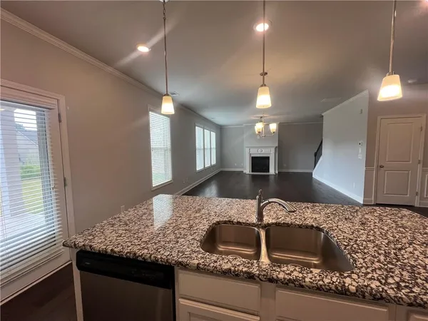 a kitchen with granite countertop a sink and a wooden cabinets