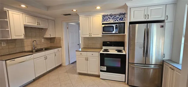 a kitchen with stainless steel appliances and refrigerator