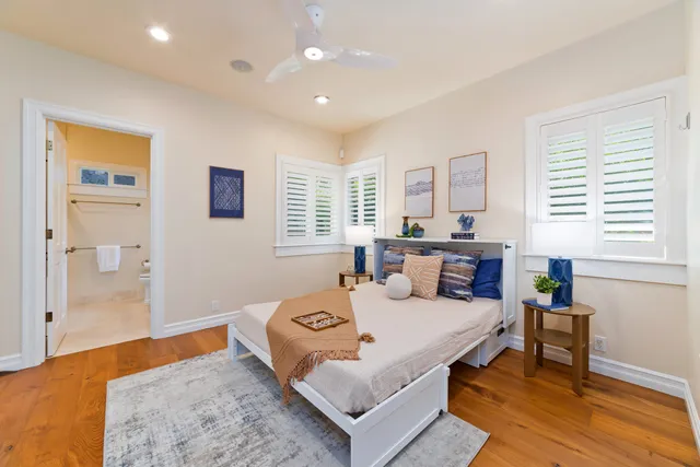 a bathroom with a granite countertop sink a large mirror a toilet and a shower