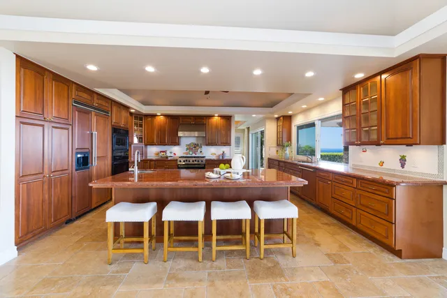 a kitchen with stainless steel appliances kitchen island granite countertop a table and chairs in it