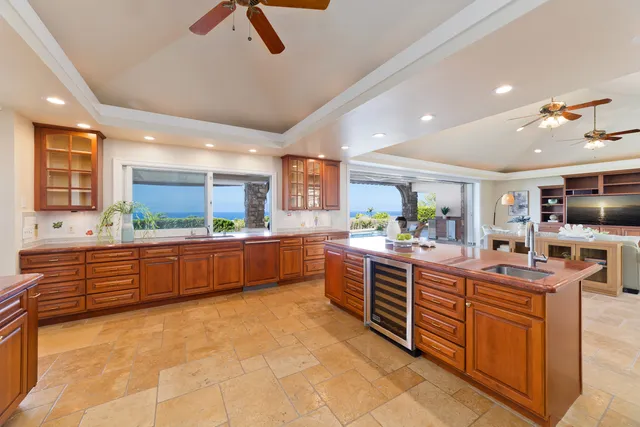 a large kitchen with stainless steel appliances a large counter top a stove and a sink