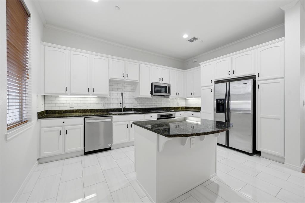 4330 McKinney Avenue, Unit 16 Dallas, TX 75205 - Photo 10 of 34 The pretty kitchen was updated in 2026 with new subway tile backsplash, new microwave and fresh white paint.