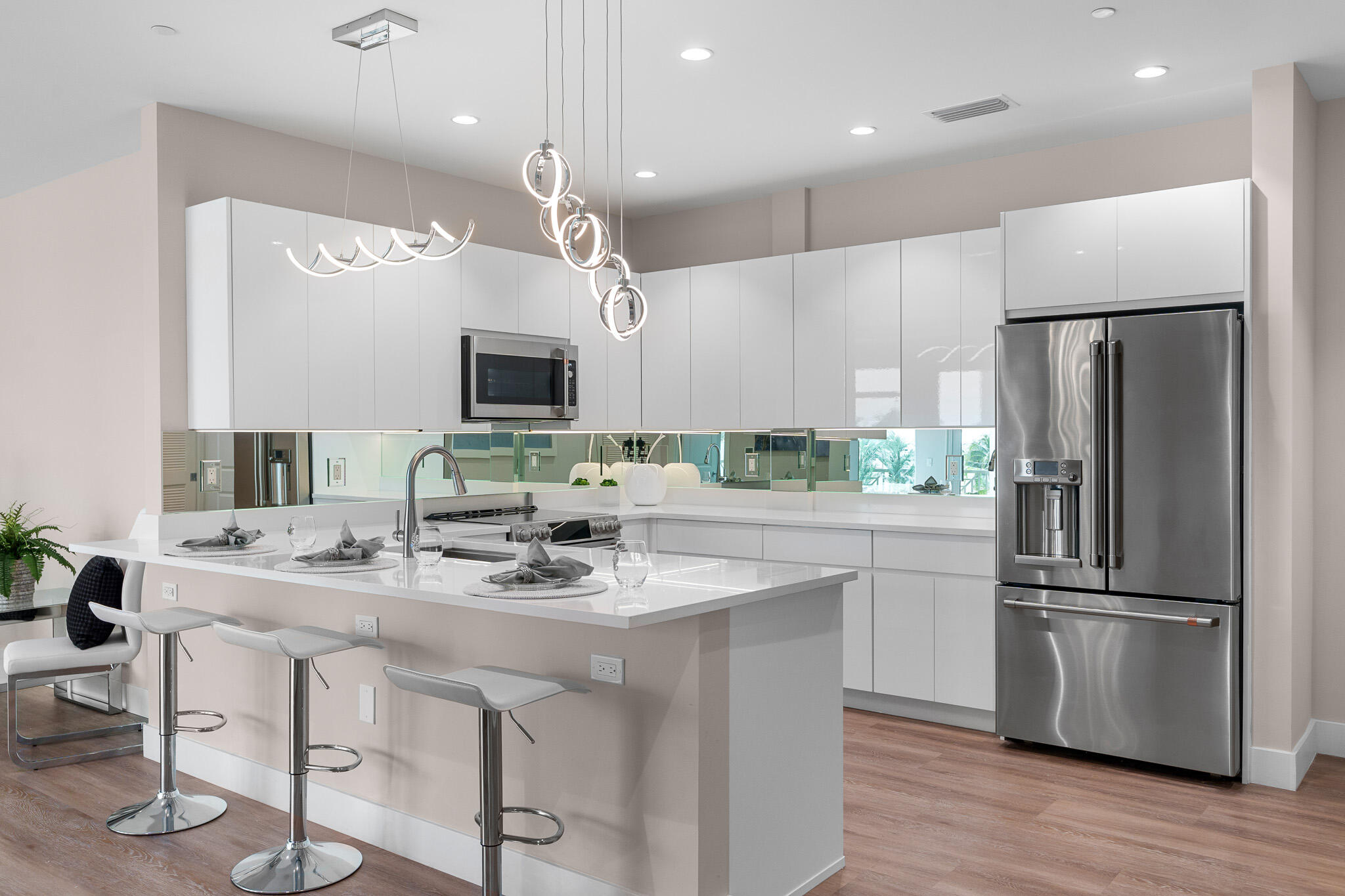 a kitchen with stainless steel appliances granite countertop a refrigerator a sink a stove a microwave and a refrigerator