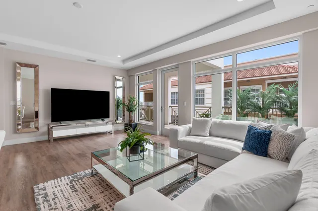 a living room with furniture a flat screen tv and a large window