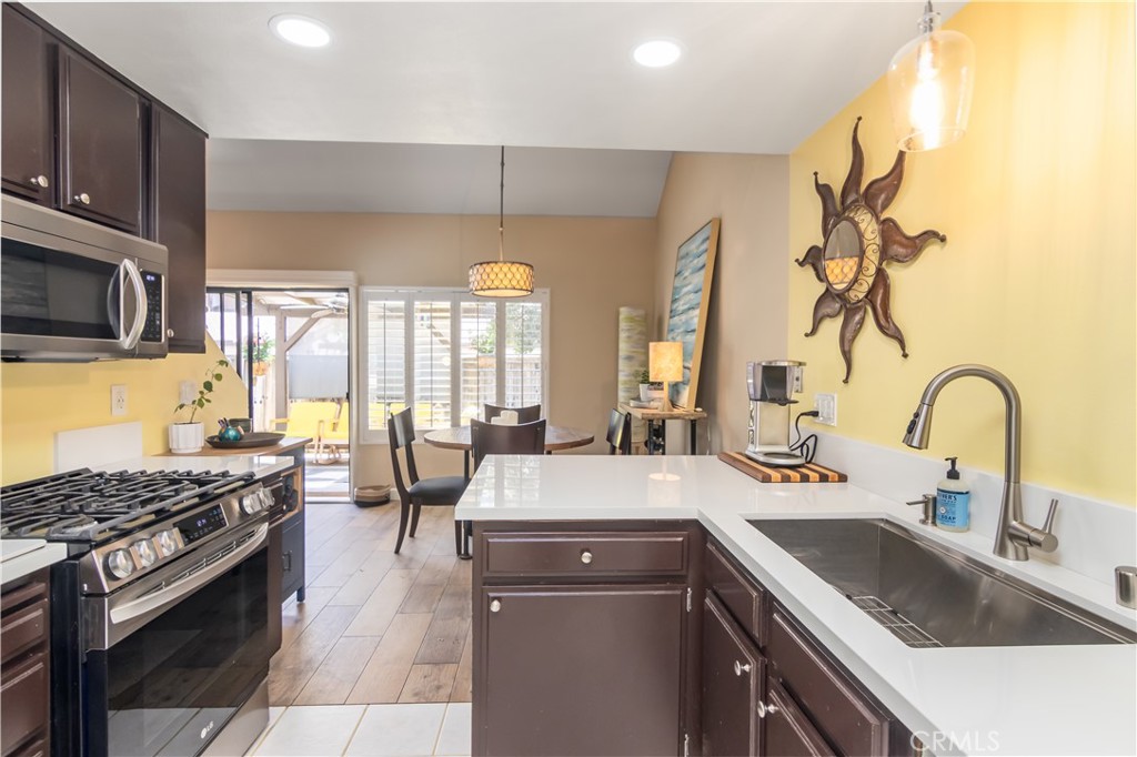 24831 Apple Street, Unit B Newhall, CA 91321 - Photo 11 of 37 a kitchen with a sink a stove and chairs