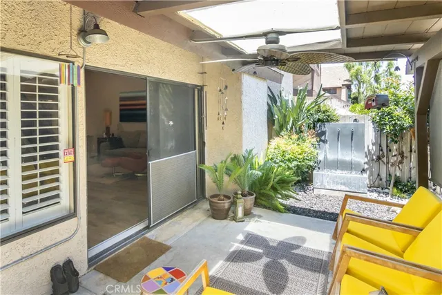 a view of a porch with chairs and potted plants