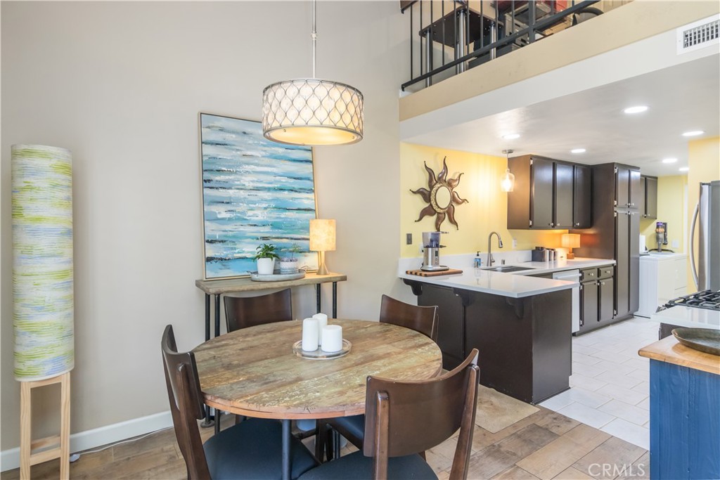 24831 Apple Street, Unit B Newhall, CA 91321 - Photo 9 of 37 a kitchen with kitchen island a dining table and chairs