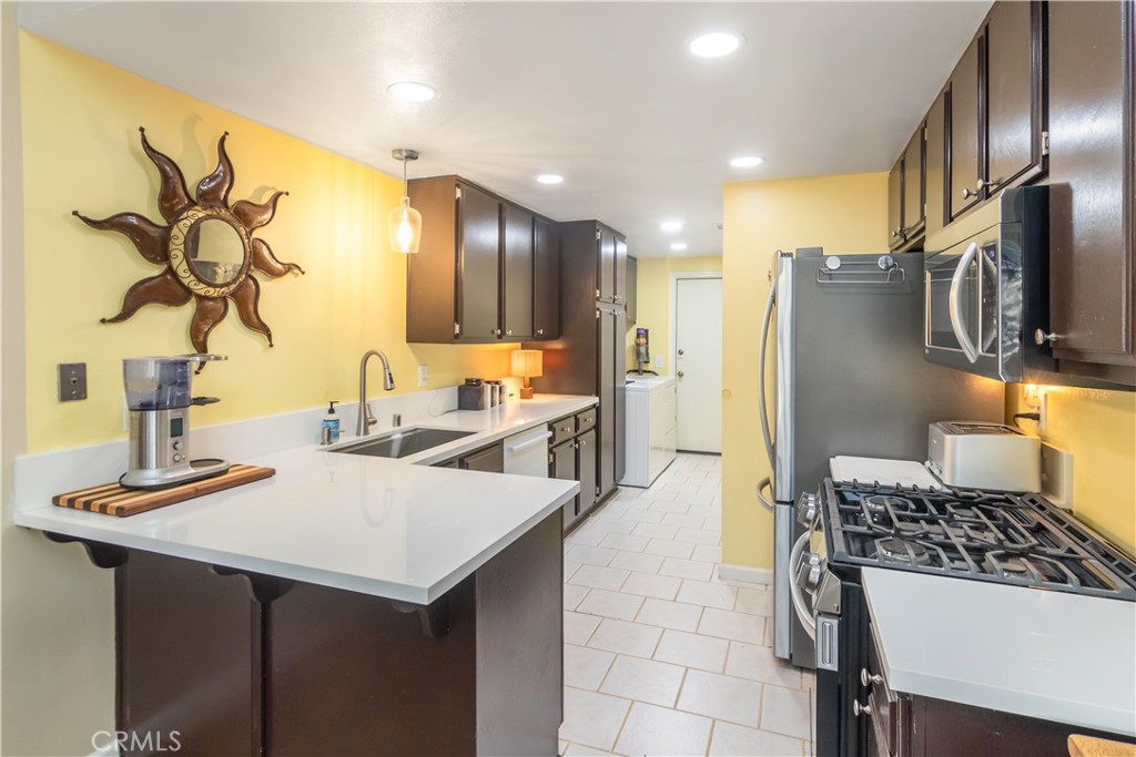 24831 Apple Street, Unit B Newhall, CA 91321 - Photo 10 of 37 a kitchen with a sink appliances and cabinets
