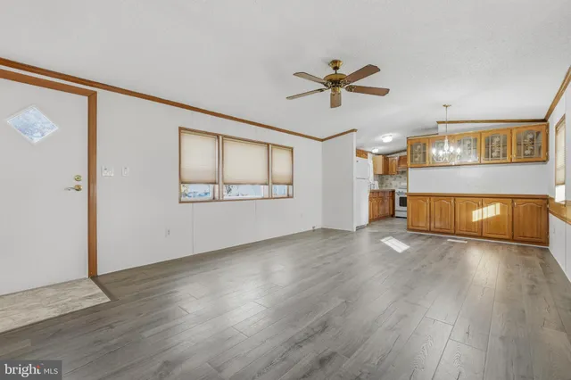 a view of a livingroom with wooden floor and a ceiling fan
