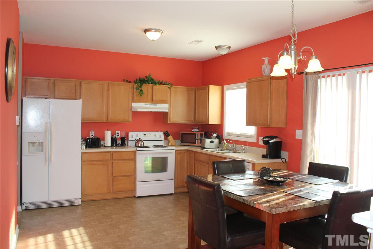 3134 Rendezvous Drive Raleigh, NC 27610 - Photo 3 of 20 a kitchen with a stove a refrigerator and a dining table