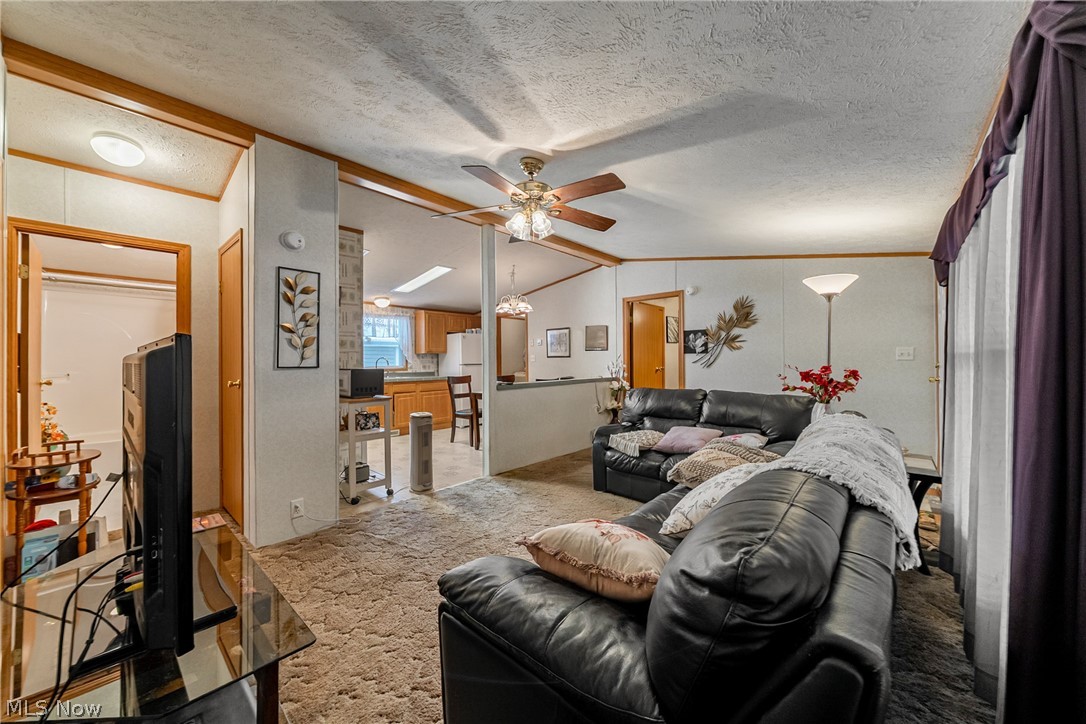 2700 Brookpark Road, Unit 513 Cleveland, OH 44134 - Photo 9 of 25 Living room featuring carpet flooring, ceiling fan, ornamental molding, and a textured ceiling