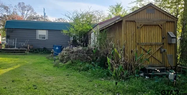 a view of backyard of house with green space