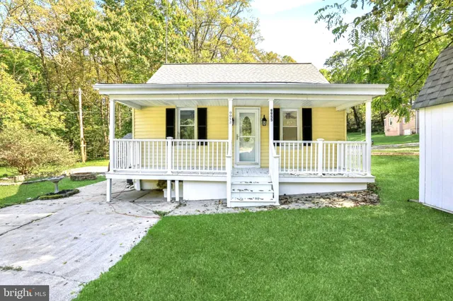 a view of a house with a yard and wooden deck