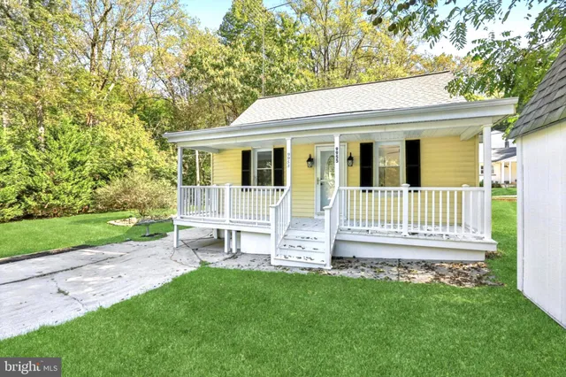 a front view of a house with a garden and yard