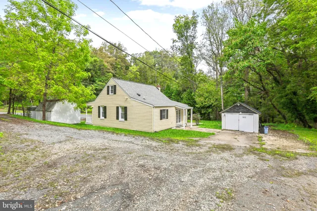a view of a house with a yard and large trees