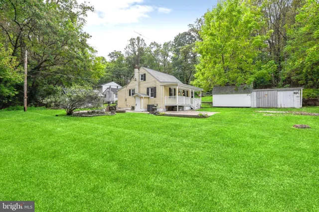 a view of a house with a yard and sitting area