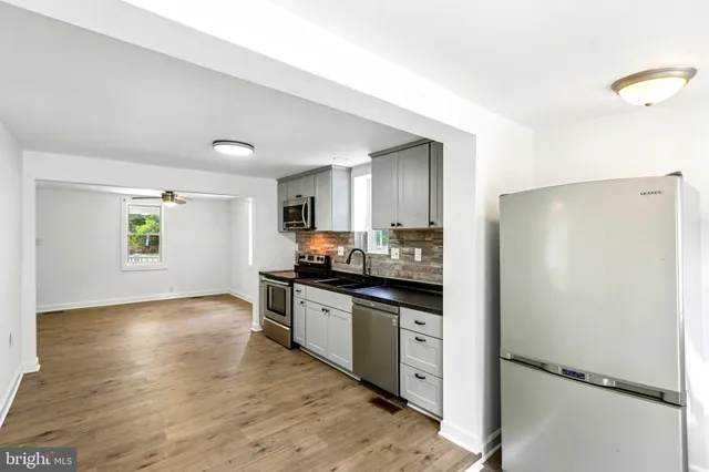 a kitchen with stainless steel appliances granite countertop a refrigerator a sink and a stove