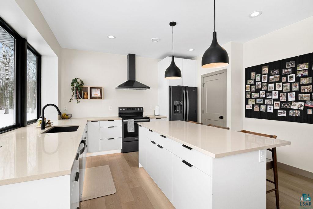 1491 Wildwood Road Duluth, MN 55804 - Photo 11 of 38 Kitchen with a center island, modern cabinets, white cabinets, and electric range