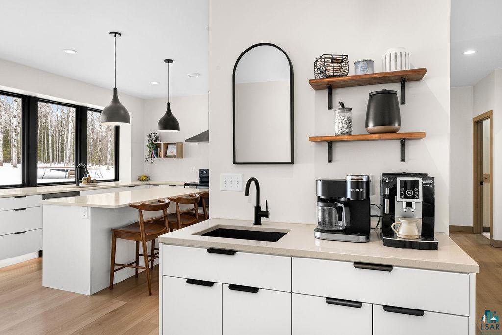 1491 Wildwood Road Duluth, MN 55804 - Photo 12 of 38 Kitchen featuring Quartz Countertops, light LVP flooring, beautiful cabinets, and large island.