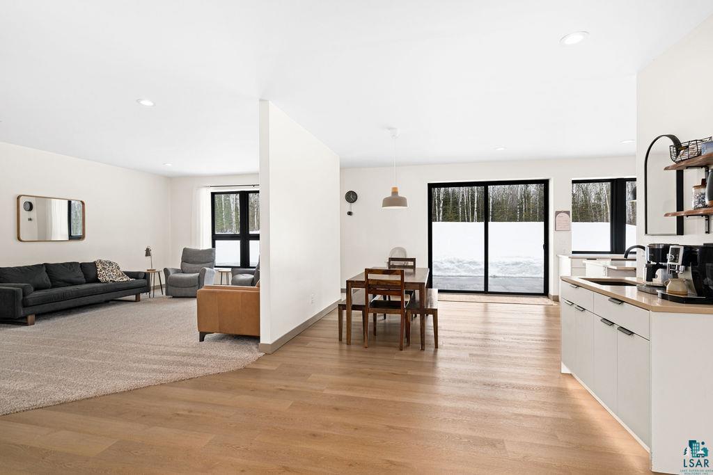 1491 Wildwood Road Duluth, MN 55804 - Photo 37 of 38 Kitchen featuring white cabinetry, light wood finished floors, open floor plan, light countertops, and decorative light fixtures