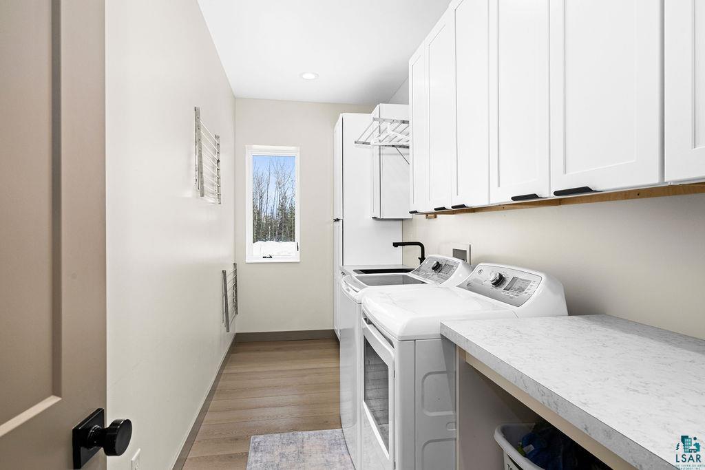 1491 Wildwood Road Duluth, MN 55804 - Photo 31 of 38 Laundry room featuring LVP flooring, washer and dryer, w generous amount of cabinetry & counter space.