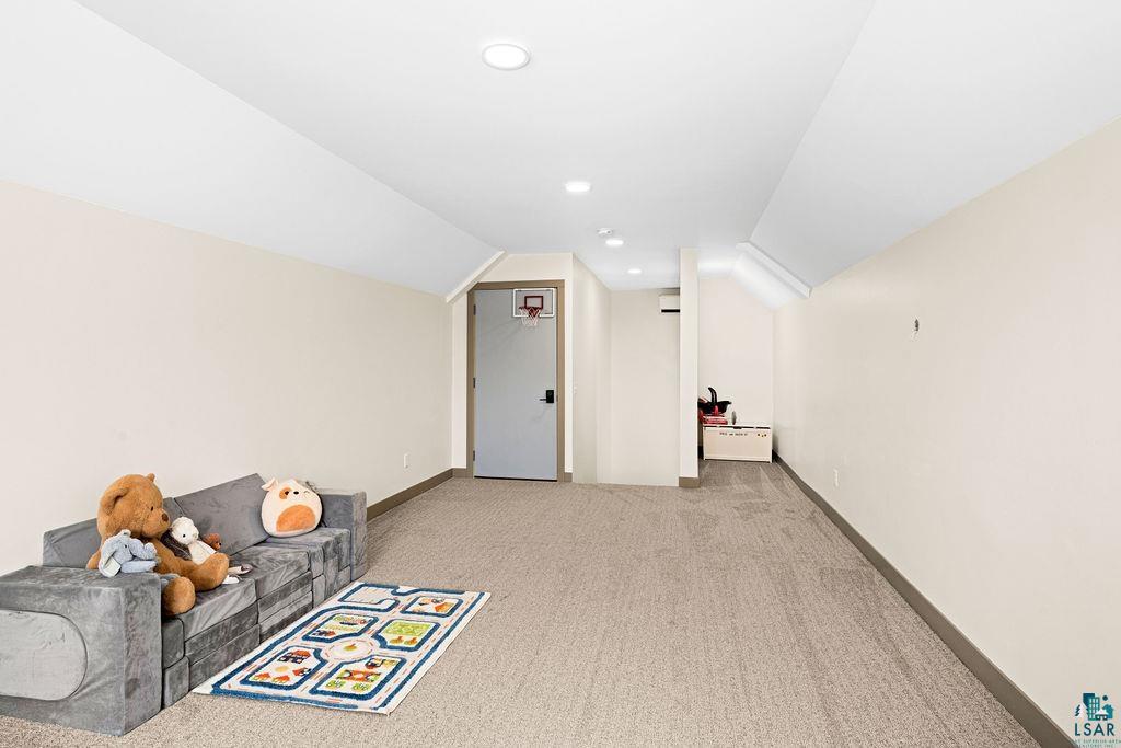 1491 Wildwood Road Duluth, MN 55804 - Photo 32 of 38 Large great room featuring light colored carpet, vaulted step ceiling, and recessed lighting.