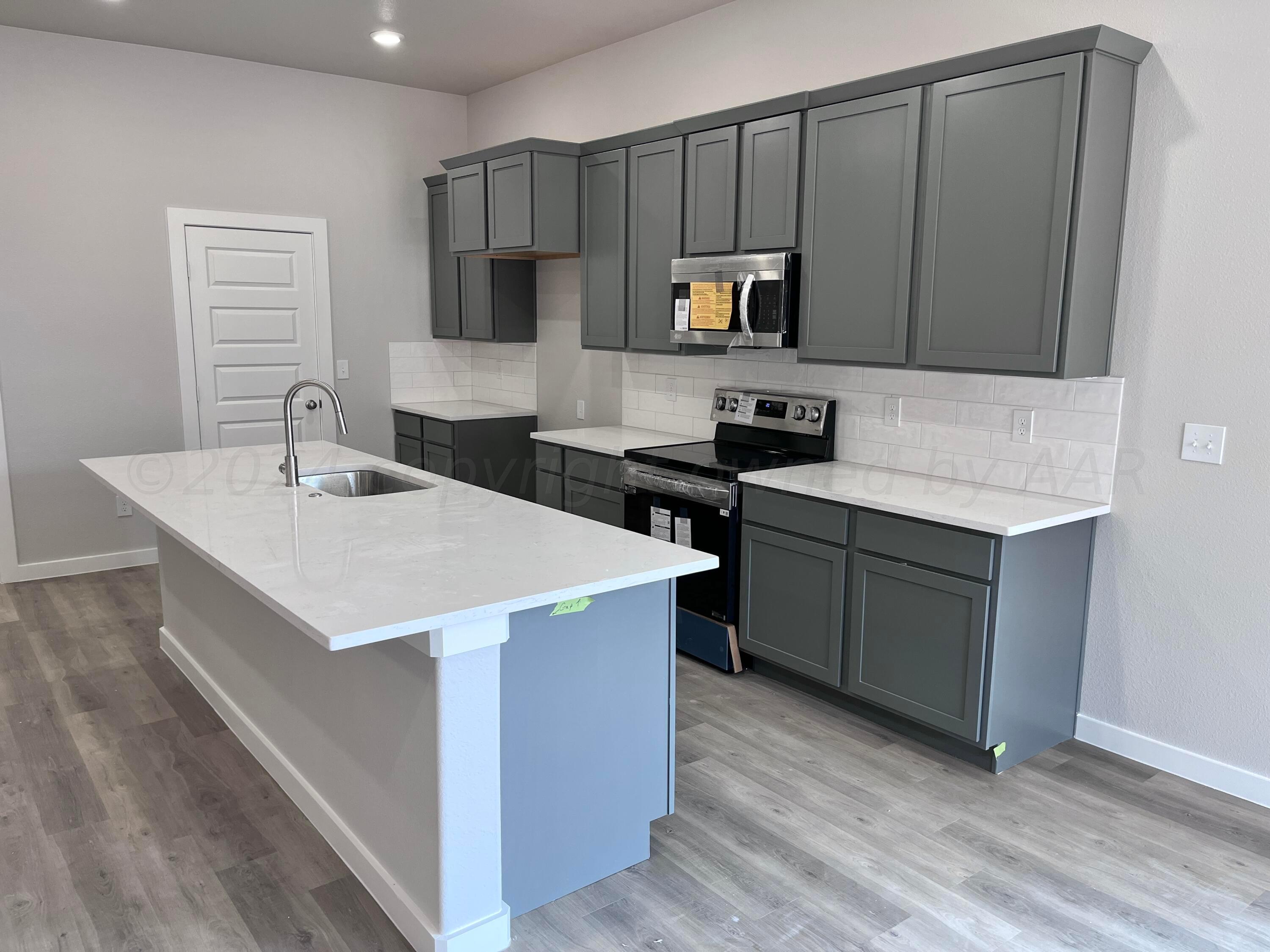1605 Moon River Road Amarillo, TX 79118 - Photo 4 of 17 a kitchen with a sink a stove a microwave and a refrigerator