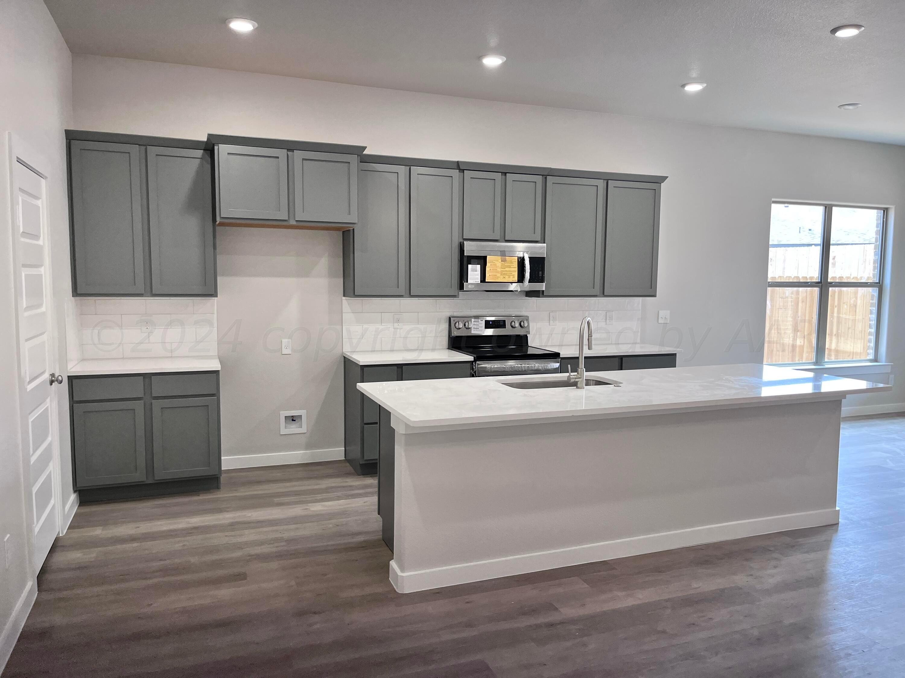 1605 Moon River Road Amarillo, TX 79118 - Photo 6 of 17 a kitchen with a refrigerator and a stove top oven
