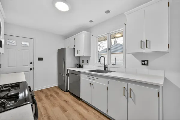 a kitchen with white cabinets and appliances