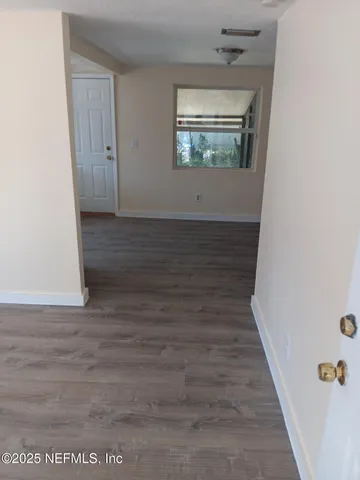 an empty room with wooden floor and window