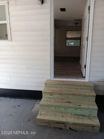 a view of an empty room with closet and wooden floor