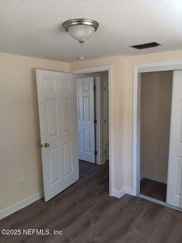 an empty room with wooden floor and ceiling fan