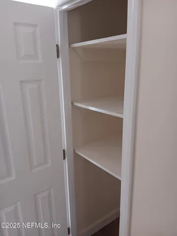 a view of empty room with window and wooden floor