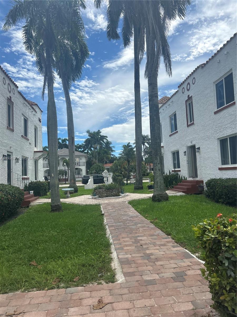 817 Tyler Street, Unit 9 Hollywood, FL 33019 - Photo 1 of 5 a backyard of a house with plants and large tree
