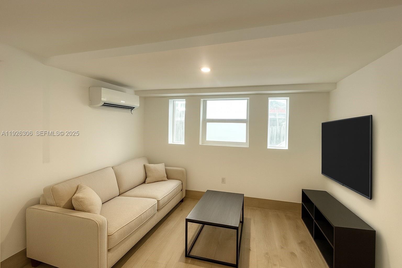 817 Tyler Street, Unit 9 Hollywood, FL 33019 - Photo 2 of 5 a living room with furniture and a flat screen tv