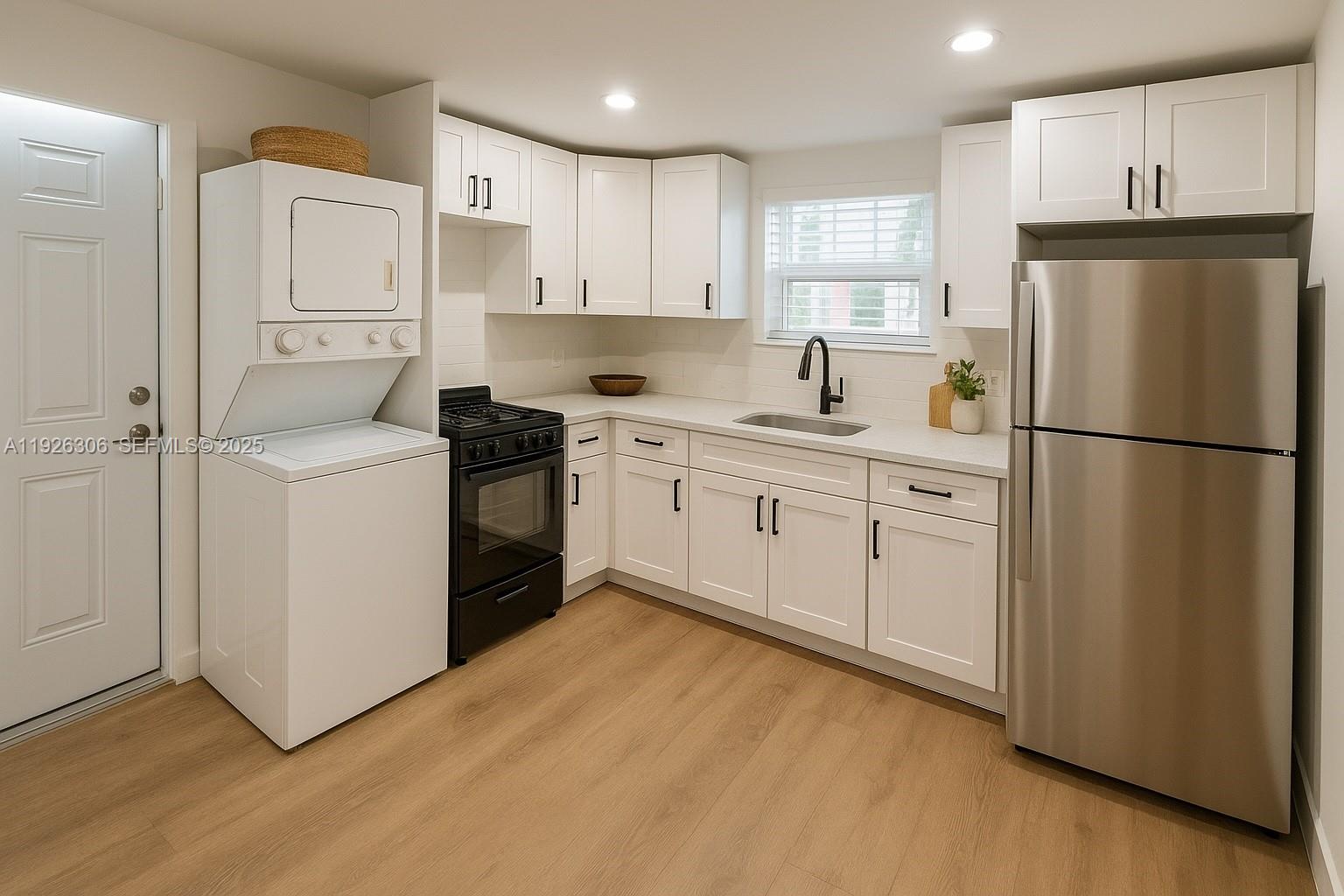 817 Tyler Street, Unit 9 Hollywood, FL 33019 - Photo 3 of 5 a kitchen with white cabinets and white appliances