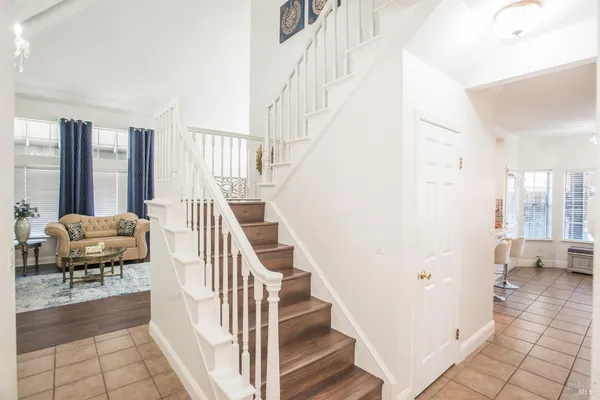 a living room with furniture a flat screen tv and kitchen view