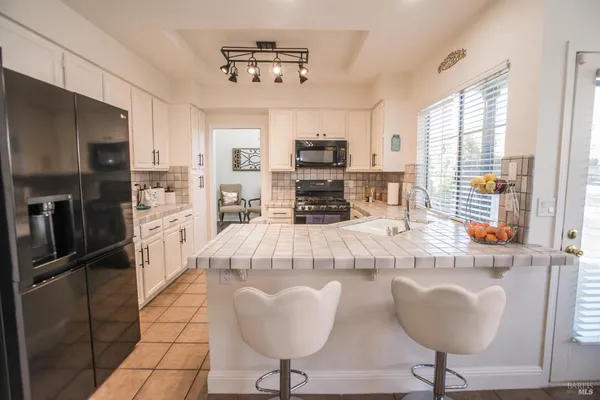 a kitchen with stainless steel appliances granite countertop a stove top oven a sink a counter top space and cabinets