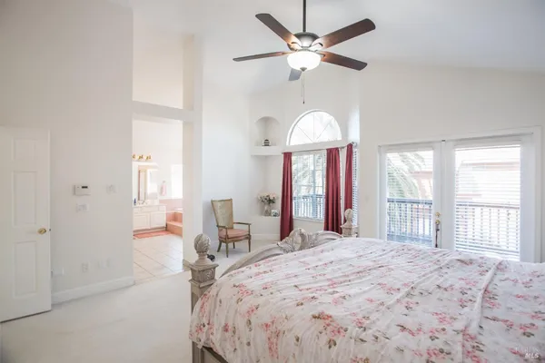 a large bed sitting in a bedroom next to a window